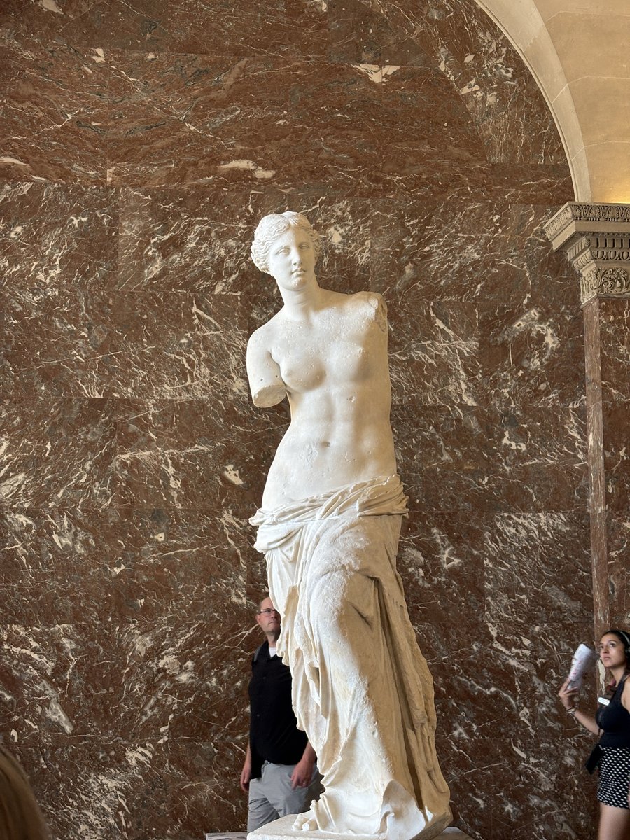 「ミロのヴィーナス（Vénus de Milo）」は、紀元前130年から100年頃に制作された高さ2メートルの古代ギリシャの大理石像で、ギリシャの愛と美の女神アフロディーテを描いたものと広く考えられています。 1820年にエーゲ海のミロス島で農夫によって発見され、その後まもなくフランスのルイ18世に贈呈されて以来、ルーヴル美術館で最も愛される名品の一つとなっている。 フランスに運ばれる前に失われたことで有名な両腕の行方は、今もなお美術史上の大きな謎の一つであり、リンゴや鏡を持っていたという説から、柱にそっと寄りかかっていたという説まで、様々な説が提唱されている。