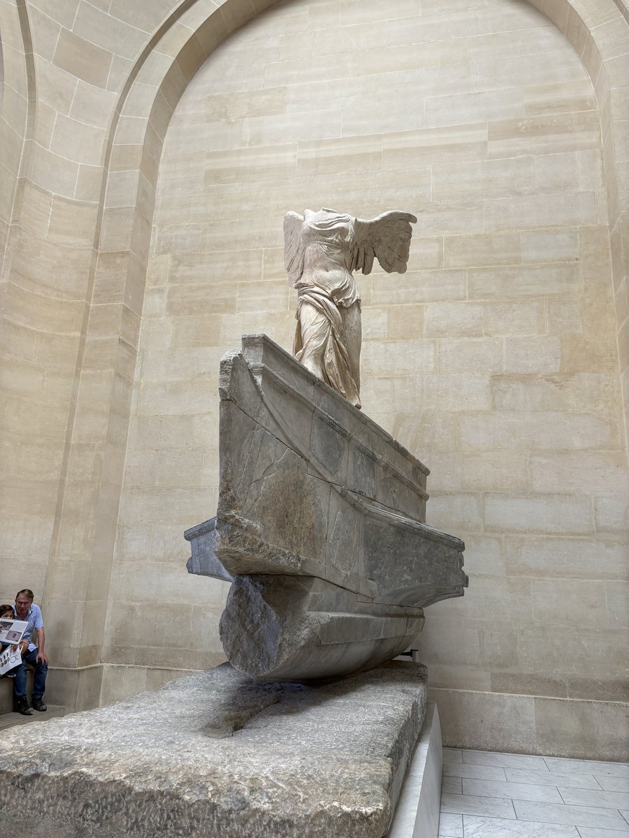 『サモトラケのニケ』（Victoire de Samothrace）は、紀元前200年頃のヘレニズム時代のギリシャの大理石像で、戦艦の船首に降り立つ勝利の女神ニケを描いています。 現在はルーヴル美術館のダルー階段の最上部に展示されており、風になびく衣と躍動感あふれる姿勢は、失われて久しい頭部や両腕がないにもかかわらず、この像を史上最も称賛される彫刻の一つにしています。